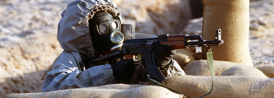 Syrian soldier aims an AK47 assault rifle from his position in a foxhole during a firepower demonstration, part of Operation Desert Shield.